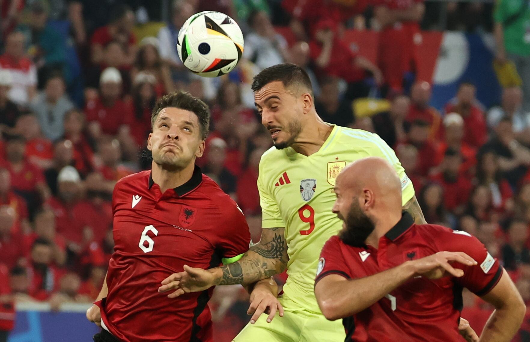 Joselu, de España y Berat Djimsiti de Albania, disputan una pelota en un momento del partidp.