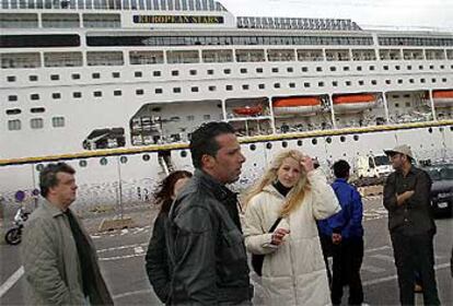 Un grupo de pasajeros del crucero, ayer ante el buque <i>European Stars.</i>