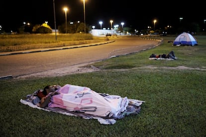 Ciudadanos venezolanos duermen en el césped frente a la estación de autobús interestatal de Boa Vista, en Brasil.