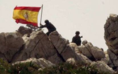 Un soldado coloca la bandera española en la isla del Perejil.