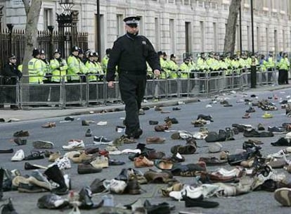Un policía británico camina entre los zapatos lanzados por un grupo de manifestantes cerca de Downing Street, en Londres.