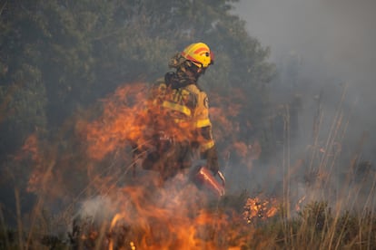 Un integrante de la 'Brigada Hormiga' apaga un fuego durante el incendio de Pentes, Ourense, este miércoles.