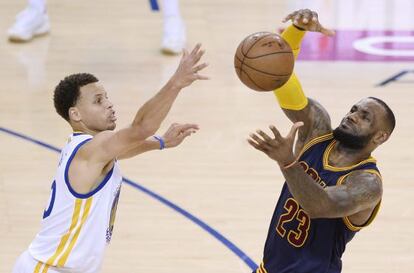 Stephen Curry y LeBron James pugnan por un balón.