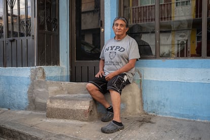 Jaime González sentado en una barda que construyó para que el agua no entre a su casa.
