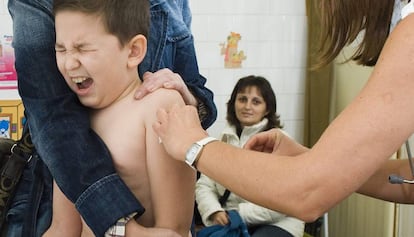 Un nen se sotmet a una vacunació.