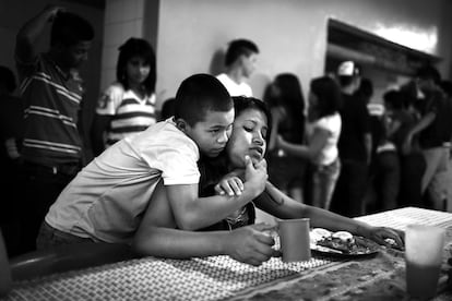 Un chico y una chica juegan ante la comida que les da el centro. Los dos sexos están separados en distintos corredores, aunque la vida allí sea en común. Una de las finalidades de Casa Alianza es favorecer una convivencia respetuosa y ofrecer educación sexual para los adolescentes.