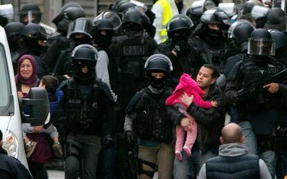 Residentes son evacuados durante la operación policial en Saint-Denin, al norte de París (Francia).