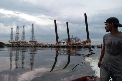 Un pescador observa una vetusta infraestructura en el lago Maracaibo (Venezuela).