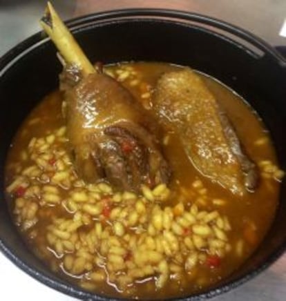 Plato de arroz meloso con gallo de corral.