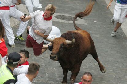 En la foto, uno de los toros empitona a un mozo en el tramo de la Cuesta de Santo Domingo.