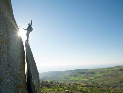 Un escalador se hace un selfie en lo alto de una roca.