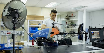 Un empleado de la empresa Alpha con uno de los drones en forma de helicóptero que comercializa.