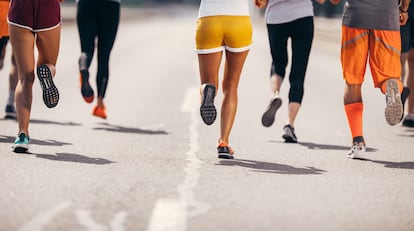 Large group of unrecognizable marathon runners having a race on the road. Copy space.