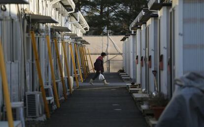 Mulher caminha pelas casas temporárias em Tamura, Fukushima.