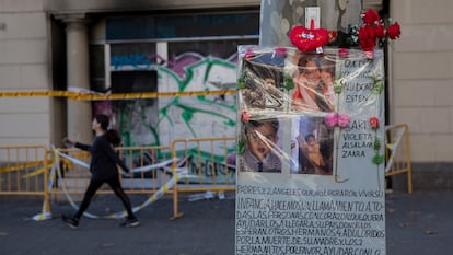 Flores y un cartel con fotos en recuerdo de la familia que murió en el incendio del 30 de noviembre de 2021, unos días después, ante el local ocupado donde vivían.