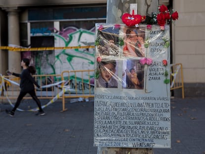 Flores y un cartel con fotos en recuerdo de la familia que murió en el incendio del 30 de noviembre de 2021, unos días después, ante el local ocupado donde vivían.