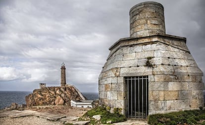 El faro de Vilán, al fondo, y la antigua linterna de aceite, en primer plano, en la Costa da Morte (A Coruña).