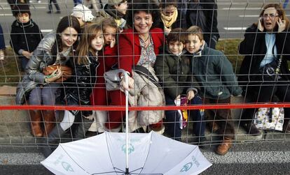 Carmen Sanz y su hijo Jorge (a su izquierda), asisten a una cabalgata de Reyes en Madrid. Llevan un paraguas para recoger más caramelos