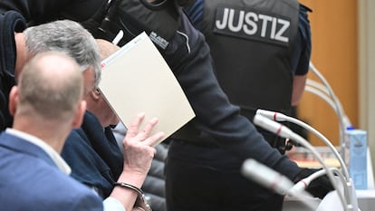 Un acusado se cubre la cara este lunes en el tribunal de Stuttgart.