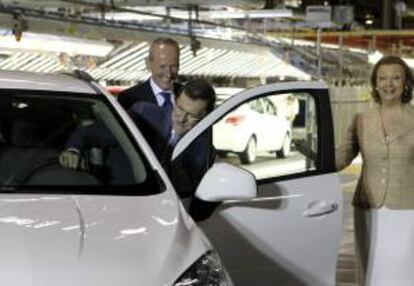 El presidente del Gobierno, Mariano Rajoy, junto a la presidenta del Gobierno de Aragón, Luisa Fernanda Rudi, y el presidente-consejero delegado de General Motors Europa, Karl-Thomas Neumann (i), se sube a un Opel Mokka, durante la visita que ha realizado hoy a la factoría de General Motors España, en Figueruelas (Zaragoza).