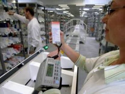 Una mujer escanea con un aparato portátil el código de barras de un medicamento mientras realiza el pedido de fármacos. EFE/Archivo