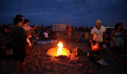 Un grupo de j&oacute;venes junto a una hoguera en la playa valenciana de la Malvarrosa.