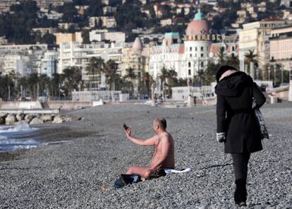 Un hombre en traje de baño se toma un selfi en la playa del Paseo de los Ingleses el 17 de enero de 2017 en Niza (Francia).