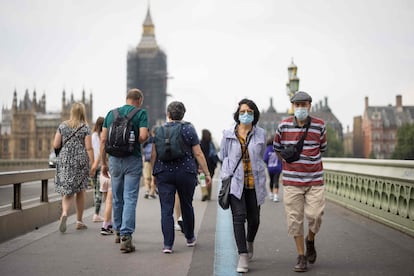 Várias pessoas cruzam a ponte de Westminster em Londres na segunda-feira.