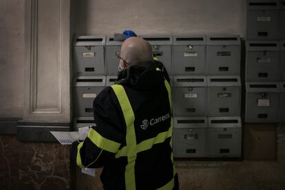 Un cartero distribuye el correo en un edificio de Barcelona.