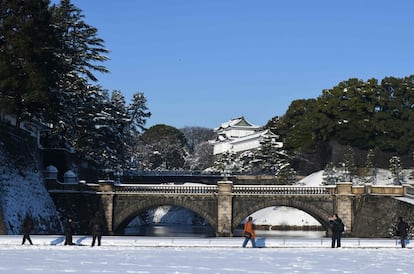Personas miran el puente cubierto de nieve, cerca del Palacio Imperial en Tokio (Japón), el 23 de enero de 2018.