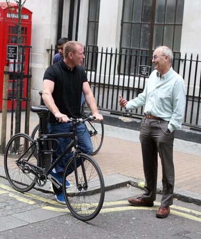 Guy Ritchie hace una pausa en su pedaleo para hablar con un amigo