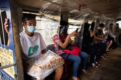 Varios pasajeros separados por plásticos viajan en un taxi colectivo en la ciudad de Makati (Filipinas).