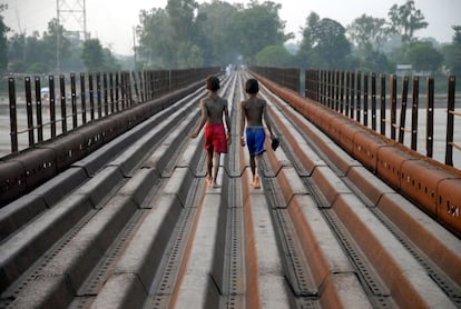 India children walk along an old bridge at Phillaur, around 50 kms from Jalandhar on September 24, 2015. AFP PHOTO / SHAMMI MEHRA