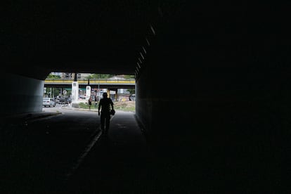 Un hombre recorre un bajopuente en Caracas.