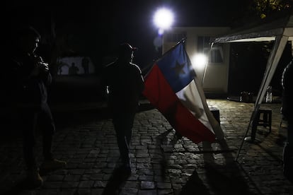 Un hombre con una bandera chilena llega al comando del Partido Republicano, a la espera de resultados de los comicios para Consejeros Constitucionales, Santiago (Chile).