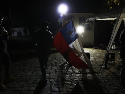 Un hombre con una bandera chilena llega al comando del Partido Republicano, a la espera de resultados de los comicios para Consejeros Constitucionales, Santiago (Chile).