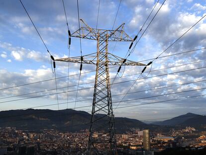 Una torre de transporte de energía perteneciente a red eléctrica, con Bilbao al fondo.
