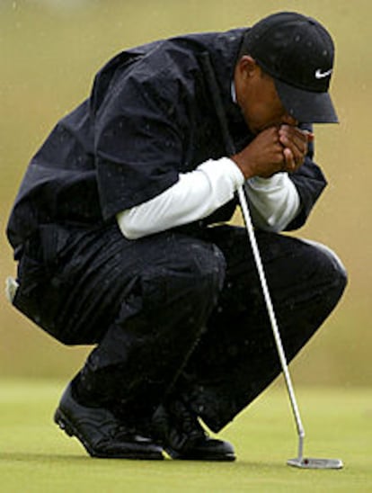 Tiger Woods trata de calentarse las manos en la boca en un momento de su recorrido.