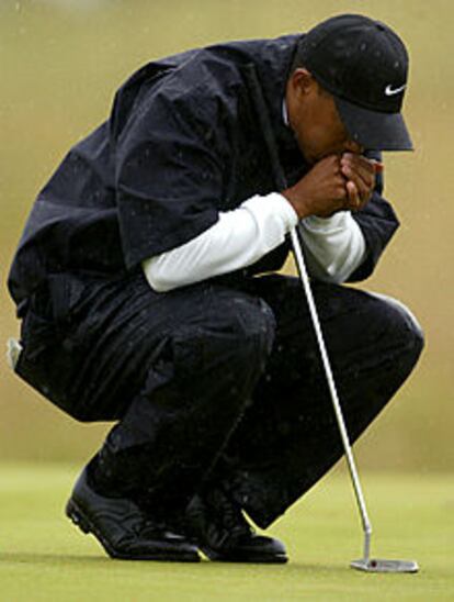 Tiger Woods trata de calentarse las manos en la boca en un momento de su recorrido.