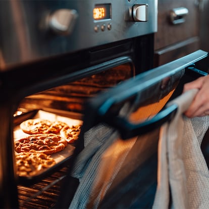 Una persona abriendo el horno.
