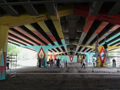 Vecinos del barrio de San Crist&oacute;bal pintan un moral en los bajos de un puente.