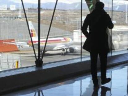Un pasajero observa un avión de Iberia en el aeropuerto de Barajas en Madrid.