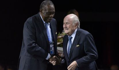 Sepp Blatter le estrecha la mano a Issa Hayatou.