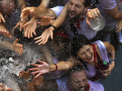 JÓvenes reciben con alivio agua desde los balcones el dÍa del Chupinazo, que da inicio a las famosas fiestas de San FermÍn.