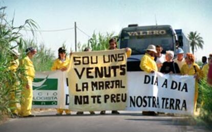 Varios ecologistas se encadenaron ayer para impedir el paso de los camiones que aterran el marjal.