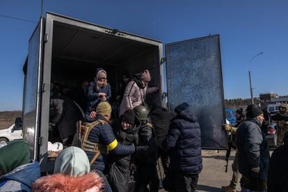 Efectivos del Ejército ucranio ayudan a bajar de una furgoneta a civiles evacuados de Irpin, este jueves. Los militares se dividen las tareas en Irpin. En el frente, trata de frenar el avance de las tropas rusas. En la retaguardia, ayudan junto a los milicianos a evacuar a la población.