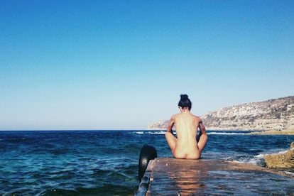 Una mujer toma el sol en una playa de Formentera, en la islas Baleares.
