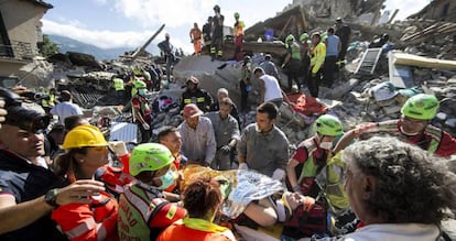 Una mujer es transportada en una camilla por los equipos de rescate en Amatrice.