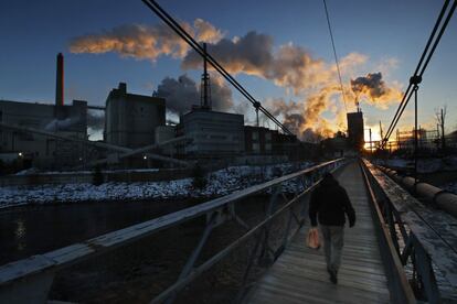 Un hombre cruza un puente peatonal en el camino hacia su trabajo en la fábrica de papel ND, en Rumford, Maine (EE UU).