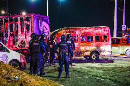 Policías resguardan el lugar donde fueron quemados cuatro vehículos en Culiacán, el 8 de mayo.